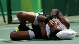 Pemain Tenis asal Jerman, Dustin Brown terkapar karena cidera saat berlaga di Olimpiade Rio 2016 melawan Thomaz Bellucci asal Brasil, Brasil (7/8). (REUTERS) 