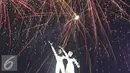 Patung monumen selamat datang dihiasi kembang api saat malam pergantian tahun di kawasan Bundaran HI, Jakarta, Sabtu (31/12). Ribuan warga yang memadati kawasan tersebut tak henti-hentinya meletupkan kembang api ke udara. (Liputan6.com/Immanuel Antonius)