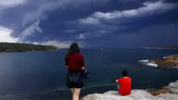 Pengunjung saat melihat awan yang gelap di Sydney, Australia, Jumat (6/11/2015). Diperkirakan Badai kencang akan melanda Australia hari ini. (REUTERS/David Gray) 