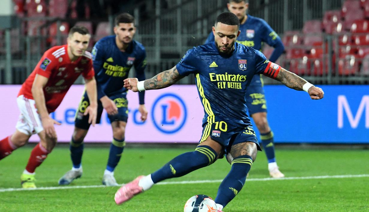 Striker Lyon, Memphis Depay melakukan eksekusi penalti ke gawang Brest yang menghasilkan gol ketiga timnya dalam laga lanjutan Liga Prancis 2020/21 pekan ke-26 di The Francis Le Ble Stadium, Brest, Jumat (19/2/2021). Lyon menang 3-2 atas Brest. (AFP/Fred Tanneau)