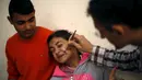 Ekspresi Alya Al-Ghafari, yang menderita cerebral palsy ketika menerima terapi sengatan lebah di klinik Rateb Samour, Kota Gaza, 11 April 2016. Samour mengobati 250 pasien sehari, dengan keluhan dari rambut rontok hingga kanker (REUTERS/Suhaib Salem)