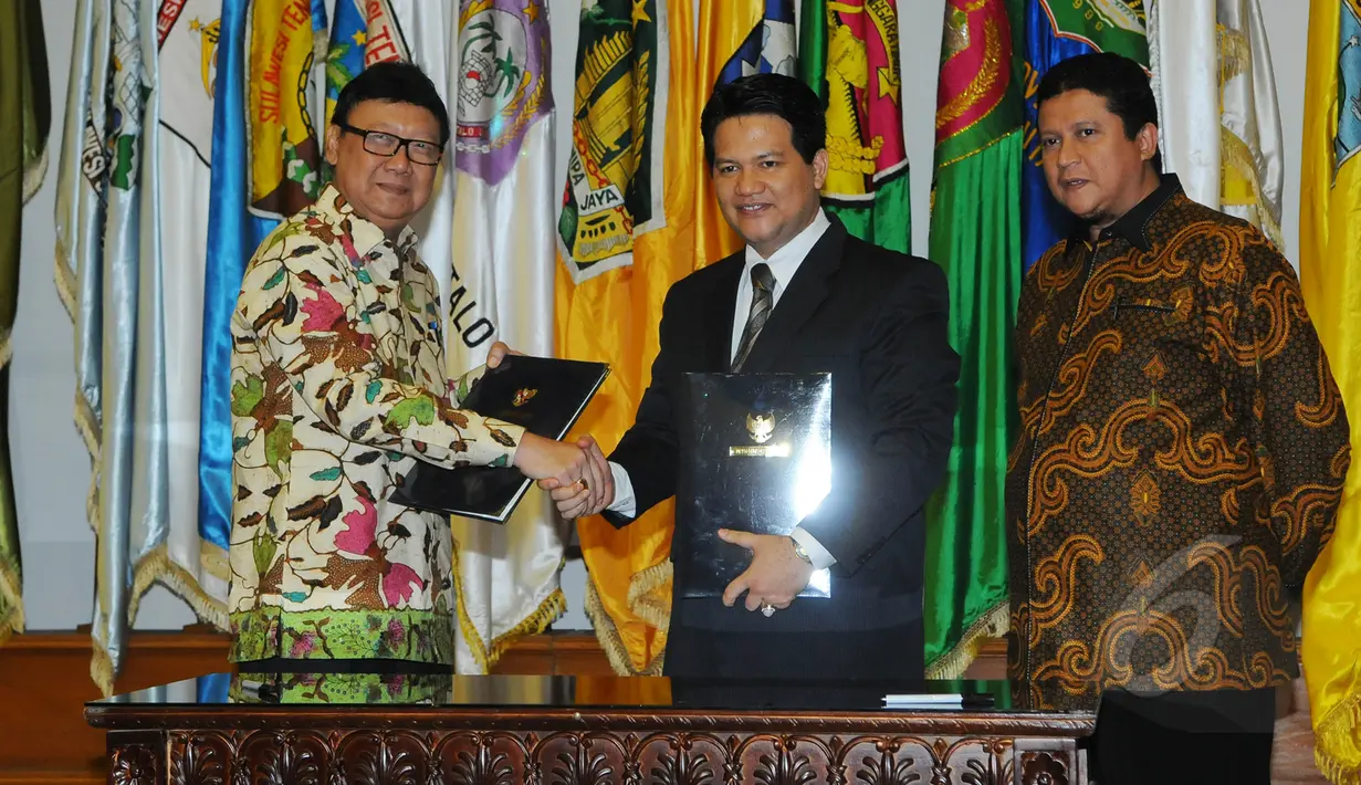 Mendagri, Tjahjo Kumolo (kiri) berjabat tangan dengan Ketua KPU Husni Kamil Manik (tengah) usai menandatangani DAK2 dari kemendagri ke KPU di Kantor Kemendagri, Jakarta, Jumat (17/4/2015). (Liputan6.com/Herman Zakharia)
