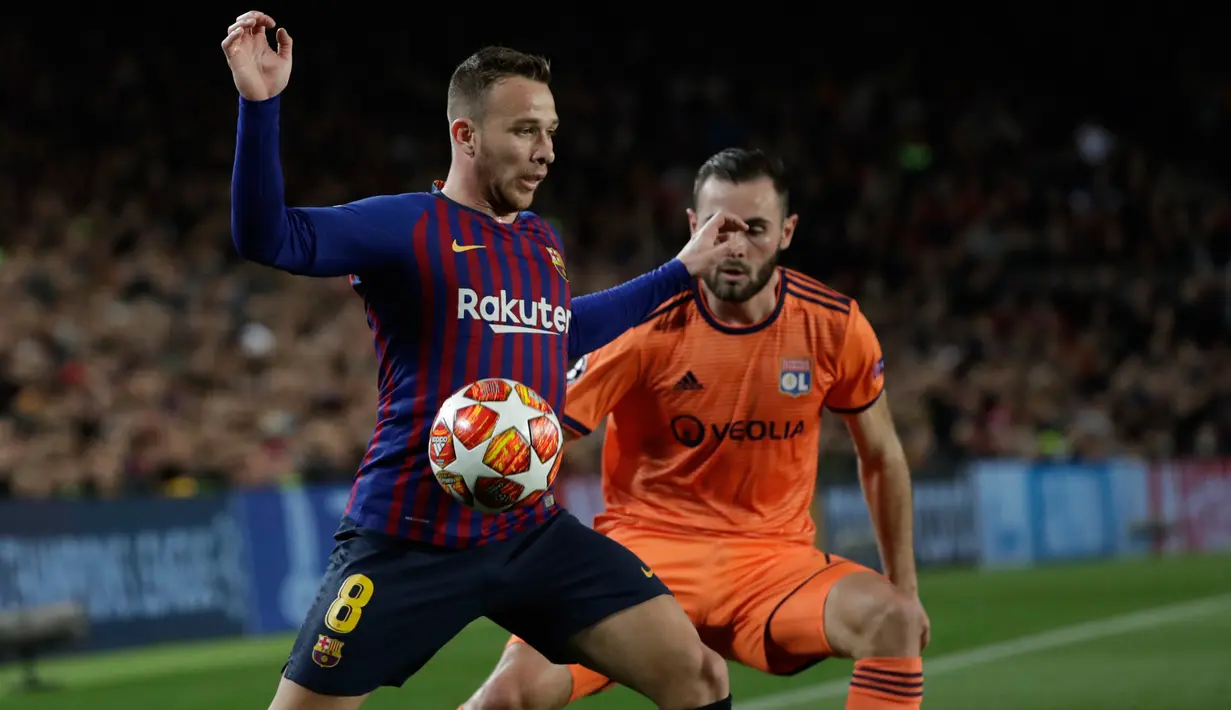Pemain Barcelona Arthur mengontrol bola di bayangi pemain Olympique Lyon, Lucas Tousart pada leg kedua 16 besar Liga Champions di Camp Nou, Rabu (13/3). Barcelona menaklukkan Olympique Lyon dengan skor telak 5-1. (AP /Emilio Morenatti)