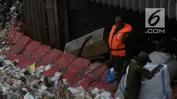 Petugas membersihkan sampah yang terbawa arus sungai Ciliwung, di Jakarta, Selasa (23/10). Dinas Lingkungan Hidup mengantisipasi terjadinya peningkatan volume sampah saat musim penghujan tiba di setiap pintu air Jakarta. (Merdeka.com/Imam Buhori)
