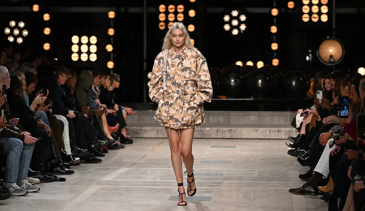 Model AS Gigi Hadid mempersembahkan kreasi untuk peragaan busana Isabel Marant Spring-Summer 2023 pada Paris Womenswear Fashion Week di Paris, Prancis, 29 September 2022. Ibu satu anak ini memamerkan kaki jenjangnya dengan sepasang sepatu hak hitam bertali. (Emmanuel DUNAND/AFP)