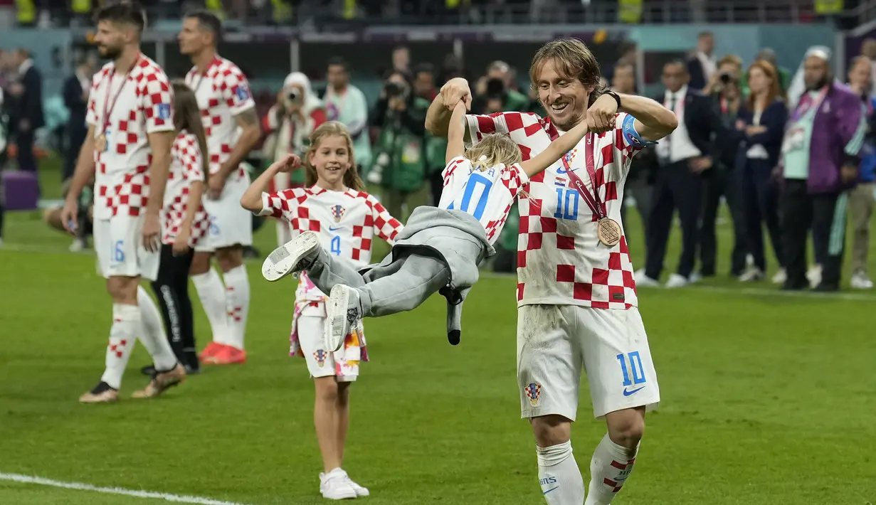 Kapten Kroasia, Luka Modric merayakan kemenangan bersama anaknya, Ema saat timnya berhasil menyabet peringkat ketiga Piala Dunia 2022 setelah mengalahkan Maroko dengan skor 2-1 pada laga yang berlangsung di Khalifa International Stadium, Doha, Qatar, Sabtu (17/12/2022). (AP Photo/Francisco Seco)