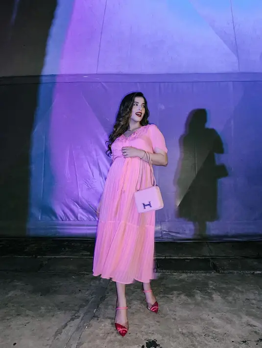 Gaya lain yang dihadirkan terlihat saat ia tampak memakai dress pink dengan material ringan, menghadirkan aksen flowy yang cantik dan indah.
