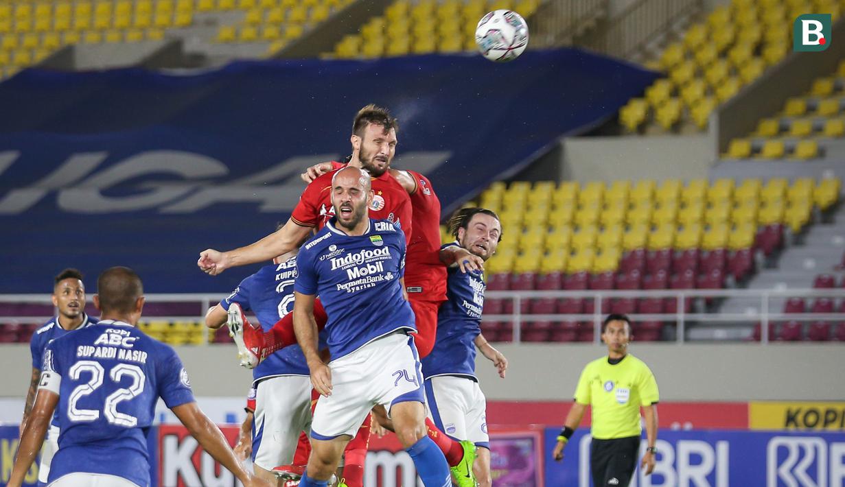 Pemain Persija Jakarta, Marco Motta (atas) berusaha mencetak gol ke gawang Perib Bandung dalam laga pekan ke-12 BRI Liga 1 2021/2022 di Stadion Manahan, Solo, Sabtu (20/11/2021). (Bola.com/Bagaskara Lazuardi)