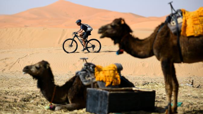 Pebalap mengendarai sepeda saat sesi latihan balap sepeda gunung Titan Gurun 2019 di sekitar Kota Merzouga, Maroko, Sabtu (27/4/2019). Trek Titan Gurun 2019 sepanjang 640 km menghubungkan antara Merzouga dan Maadid. (Franck Fife / AFP)