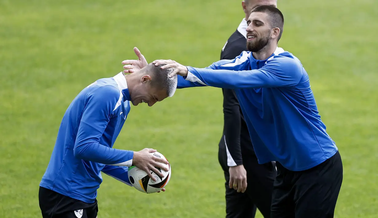 Reaksi penyerang Slovenia #11 Benjamin Sesko (kiri) saat menghadiri sesi latihan tim sepak bola nasional Slovenia selama turnamen EURO 2024, di markas tim mereka di Wuppertal, Sabtu (15/6/2024). (KENZO TRIBOUILLARD / AFP)
