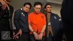 Buronan ‎kasus korupsi dana nasabah Bank Century, Hartawan Aluwi dikawal petugas keluar Bareskrim Mabes Polri, Jakarta, Jumat (22/4). Dengan pengawalan ketat anggota bersenjata laras panjang, Hartawan digelandang ke Kejagung. (Liputan6.com/Gempur M Surya)