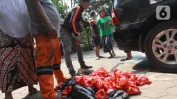 Panitia membagikan daging kurban kepada warga di Kelurahan Menteng, Jakarta Pusat, Sabtu (1/8/2020). Pembagian daging kurban tersebut berjalan lancar meskipun sebagian warga mengabaikan protokol Kesehatan. (Liputan6.com/Angga Yuniar)