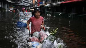 Banjir Parah Rendam Bangkok Warga Berjualan di Tengah Genangan