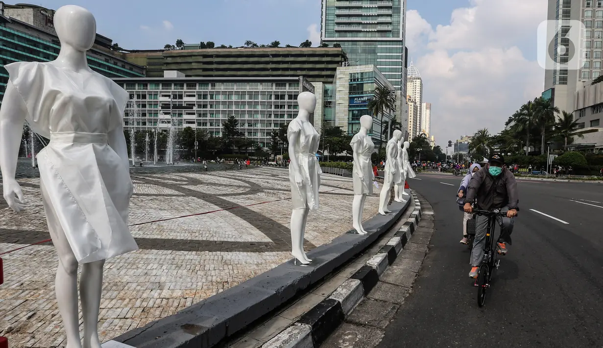 Pesepeda melintasi puluhan boneka maneken yang dipajang di Bundaran HI, Jakarta, Minggu (15/11/2020). Boneka maneken itu sebagai bentuk "Mengenang Korban Kecelakaan Lalu Lintas 2020" dan mengingatkan pengguna jalan agar selalu patuhi peraturan lalu lintas demi keselamatan. (Liputan6.com/Johan Tallo)