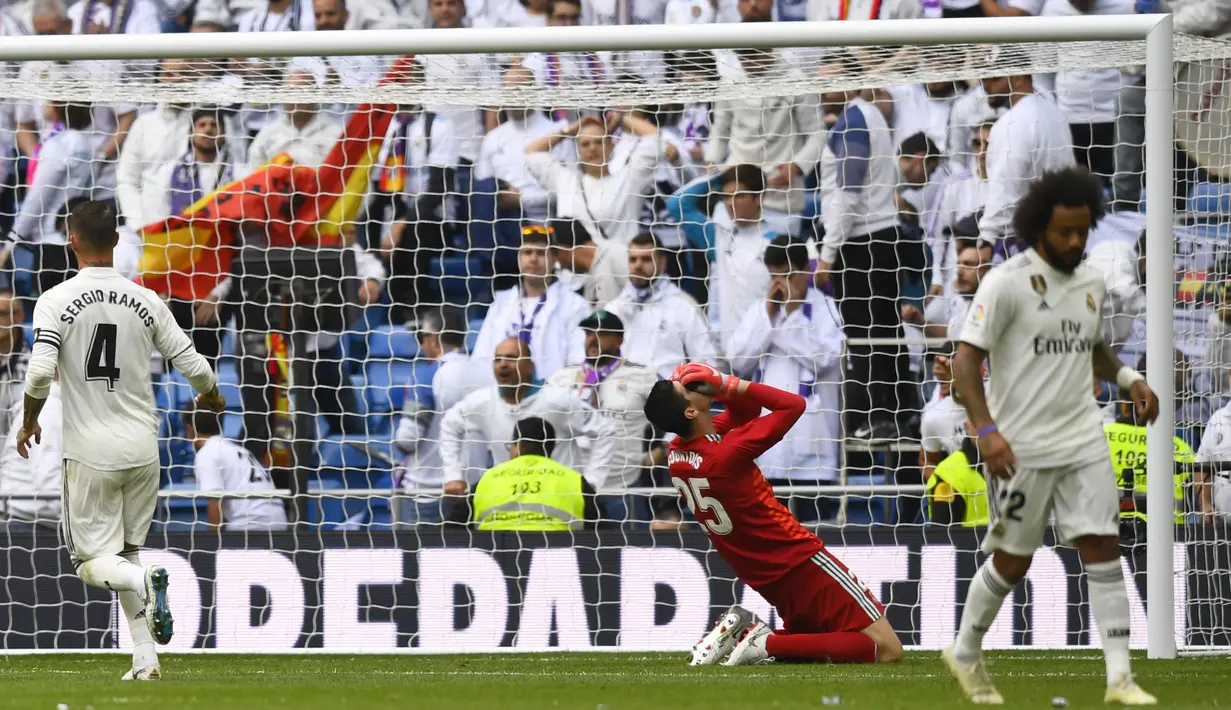 Kiper Real Madrid, Thibaut Courtois, tampak kecewa usai gawangnya dibobol Levante pada laga La Liga Spanyol di Stadion Santiago Bernabeu, Madrid, Sabtu (20/10). Madrid kalah 1-2 dari Levante. (AFP/Gabriel Bouys)