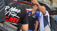 Pembalap Monster Energy Yamaha MotoGP, Fabio Quartararo, melayani permintaan foto para penggemar yang menemuinya di belakang paddock di Sirkuit Mandalika, Lombok, setelah sesi latihan bebas kedua (FP2), Jumat (13/10/2023) sore WIT. (Bola.com/Benediktus Gerendo Pradigdo)