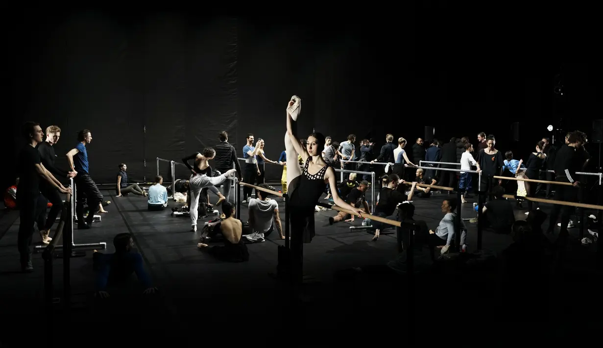 Penari Ukraina dari Balet Kota Kiev melakukan peregangan sebelum pertunjukan di Theatre de Chatelet, di Paris (8/3/2022). Pertunjukan ini sebagai bagian dari acara malam untuk mendukung Ukraina setelah invasi Rusia. (AP Photo/Thibault Camus)