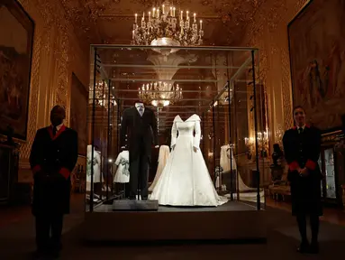Gaun pernikahan Putri Eugenie dan jas sang suami, Jack Brooksbank ditampilkan selama pratinjau media di Kastil Windsor, London, Kamis (28/2). Gaun tersebut akan dipajang sebagai bagian dari pameran yang berlangsung hingga 22 April 2019. (AP/Matt Dunham)