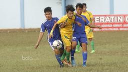 Pemain Persija U-17, Rizky Ramadhan, dihadang pemain PCM di Stadion Cendrawasih, Jakarta, Senin, (24/7/2017). Persija Muda gagal lolos fase grup Piala Suratin setelah bermain imbang 1-1 melawan PCM. (Bola.com/M Iqbal Ichsan)