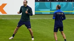 Bek Italia, Giorgio Chiellini (kiri) melakukan pemanasan selama sesi latihan di stadion Hive di London, Inggris, Senin (5/7/2021). Italia akan menghadapi Spanyol pada babak semifinal Euro 2020  di Stadion Wembley, Inggris. (AP/Matt Dunham)