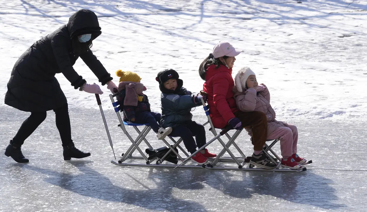 Warga menikmati hari yang cerah bermain di kanal beku saat Olimpiade Musim Dingin 2022 hampir berakhir di Beijing pada Sabtu, 19 Februari 2022. (AP Photo/Ng Han Guan)