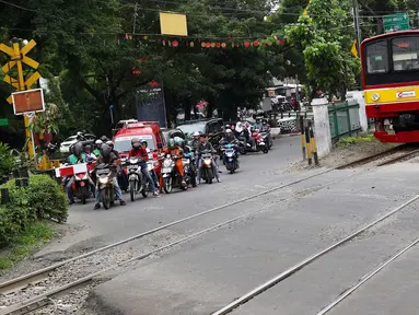 Kereta melintas di kawasan Lenteng Agung, Jakarta, Selasa (13/3). Untuk mengurai kemacetan imbas antrian kendaraan berputar balik di pintu kereta IISIP, Pemprov DKI berencana membangun flyover U-Turn di kawasan tersebut. (Liputan6.com/Immanuel Antonius)