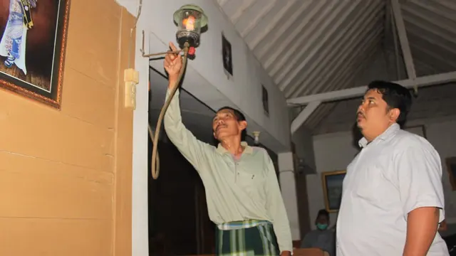 Resmihar ketika menyalakan lampu penerangan dari biogas. (Liputan6.com/ Ahmad Adirin)
