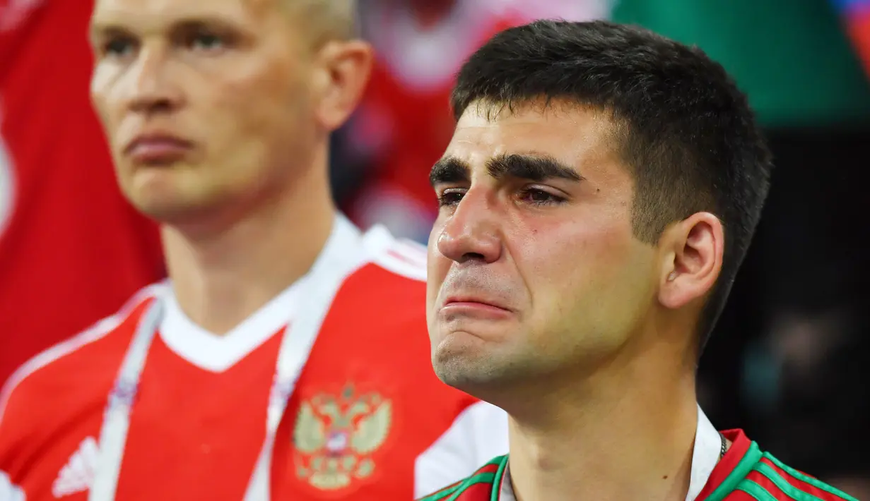 Seorang suporter menangis usai Rusia kalah dari Kroasia pada laga perempat final Piala Dunia di Stadion Olimpiade Fisht, Sabtu (7/7/2018). Rusia kalah adu penalti dengan skor 3-4 dari Kroasia. (AFP/Nelson Almeida)