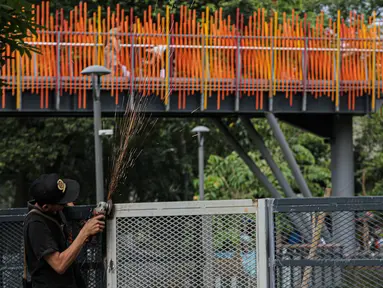 Pekerja melakukan pengelasan saat menyelesaikan pemasangan pagar yang mengelilingi area ruang terbuka hijau (RTH) Tebet Eco Park, Jakarta, Senin (12/12/2022). Pemasangan pagar tersebut membuat taman terkesan lebih rapih dan bagus. (Liputan6.com/Faizal Fanani)