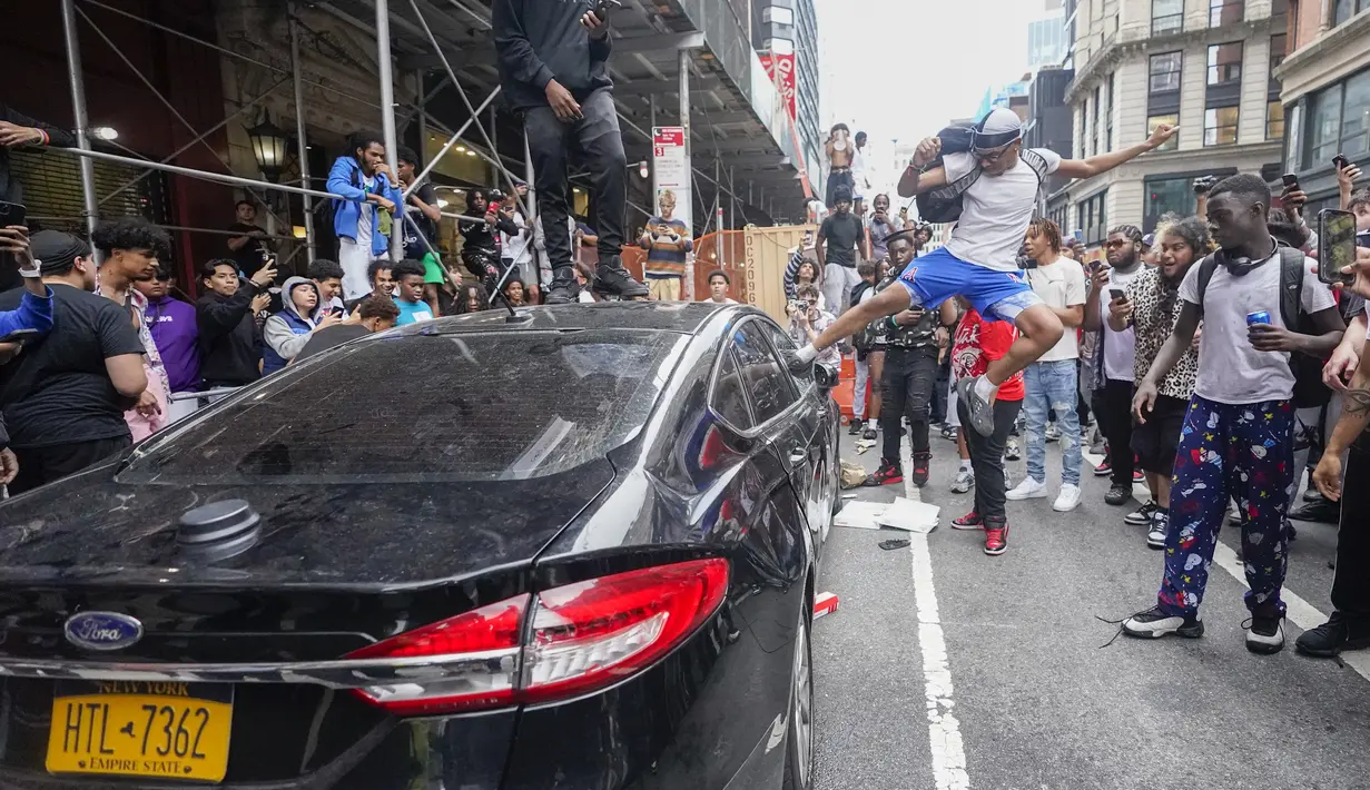 Polisi di New York City berjuang untuk mengendalikan kerumunan ribuan orang yang berkumpul di Manhattan's Union Square untuk hadiah konsol videogame kepribadian Internet yang tidak terkendali. (AP/Mary Altaffer)