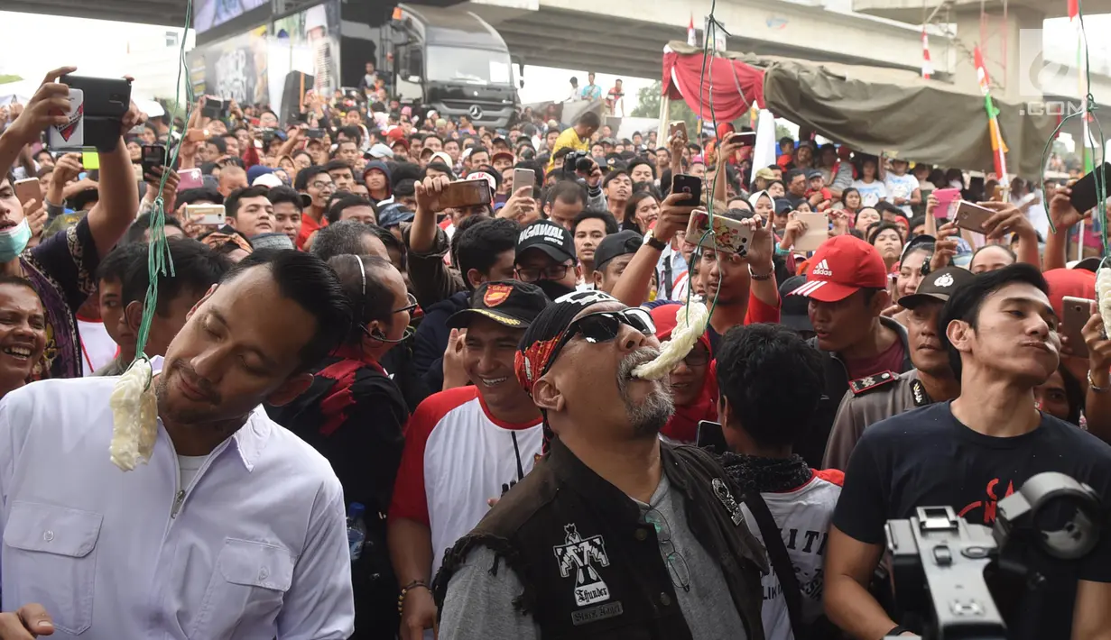 Aktor Tora Sudiro, Vino G Bastian dan Indro Warkop mengikuti lomba makan kerupuk pada Festival Kalimalang di Jakarta, Kamis (17/8). Mereka menghadiri festival Kalimalang dalam rangka promo film Warkop DKI: Reborn Part 2. (Liputan6.com/Herman Zakharia)