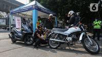 Petugas melakukan uji emisi kendaraan yang terjaring dalam uji coba tilang uji emisi di Terminal Blok M, Jakarta Selatan, Jumat (25/8/2023). Pemerintah Provinsi DKI Jakarta bersama Polda Metro Jaya melakukan uji coba tilang uji emisi di lima wilayah DKI Jakarta sebelum diberlakukan sanksi tilang pada 1 September 2023. (Liputan6.com/Johan Tallo)