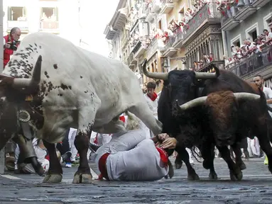 Festival San Fermin atau festival bull-run kembali dibuka di Pamplona, Spanyol, Selasa (7/7/2015). Ribuan pengunjung sangat antusias saat komplotan banteng berlari menyeruduk mereka. (Reuters/Susana Vera)