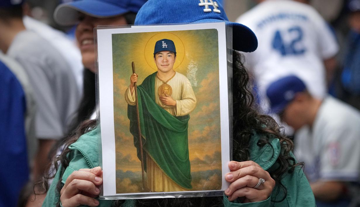 Seorang fans memegang poster bergambar pitcher Los Angeles Dodgers, Shohei Ohtani saat parade kemenangan 2025 World Series Championship di Los Angeles, California, Senin (03/11/2025) waktu setempat. (AP Photo/Jae C. Hong)