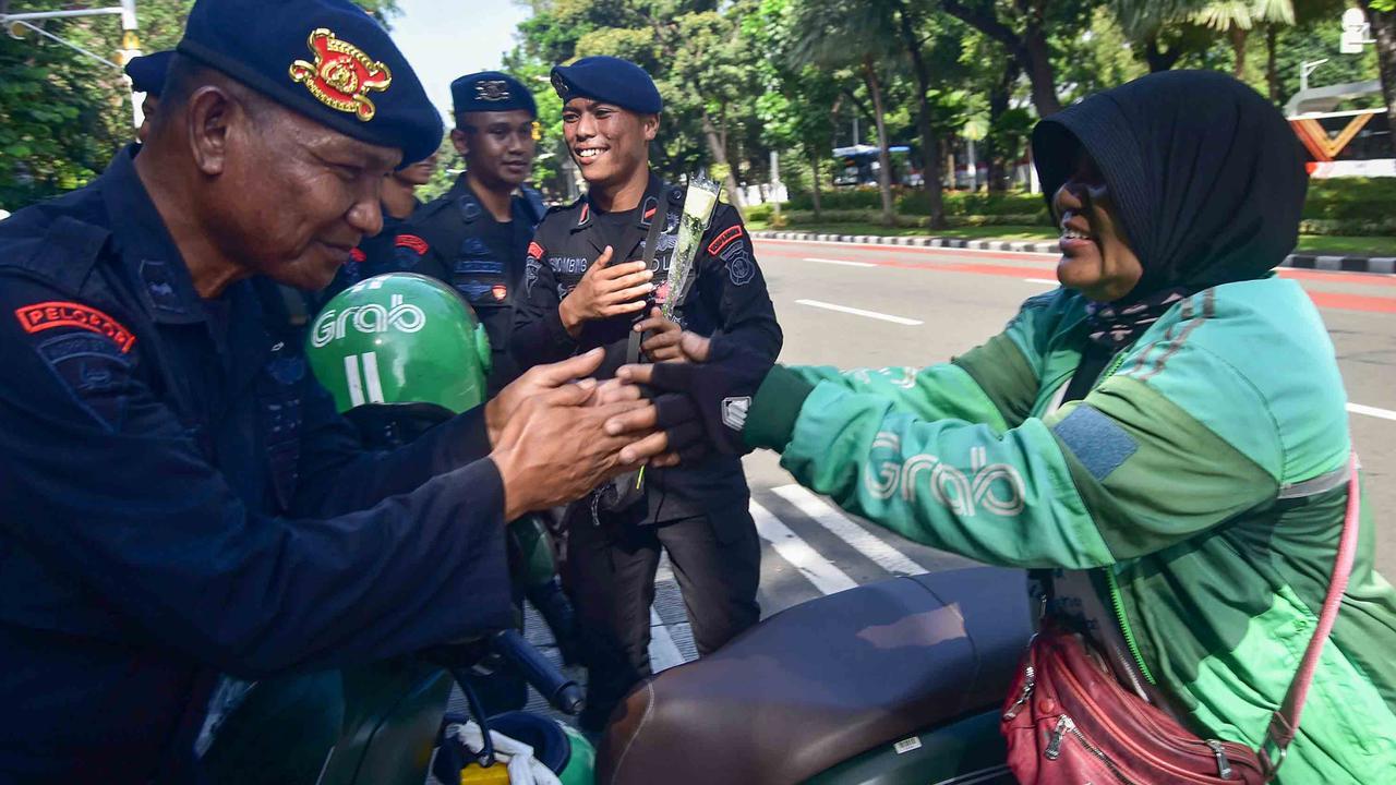 FOTO: Aksi Damai Ojol Tebar Mawar untuk Perdamaian