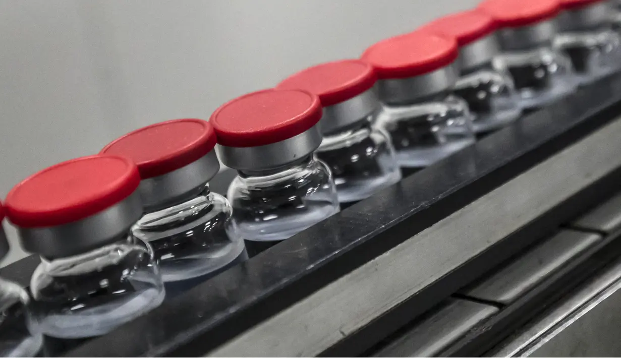 Botol vaksin Sinovac China saat di jalur produksi di laboratorium Vacsera, Kairo, Mesir, Rabu (1/9/2021). Laboratorium Vacsera di Mesir membuat vaksin Sinovac China untuk mencegah penularan virus corona. (AFP/Khaled Desouki)
