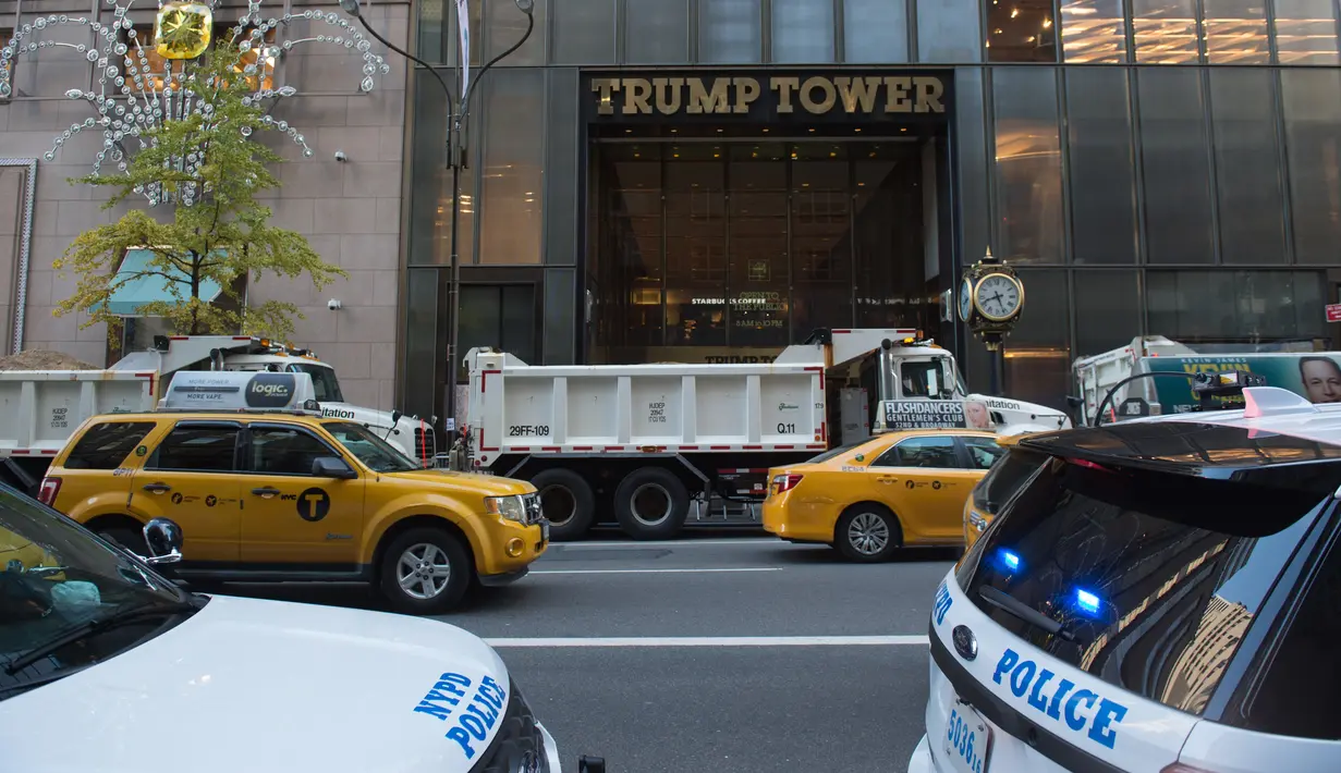 Departemen Kepolisian New York menempatkan sejumlah truk berisi pasir menutupi bagian depan Gedung Trump Tower, Selasa (8/11). Menurut sumber, truk-truk pasir itu berguna melindungi bangunan tersebut dari penyerangan mendadak. (BRYAN R. SMITH/US-VOTE/AFP)