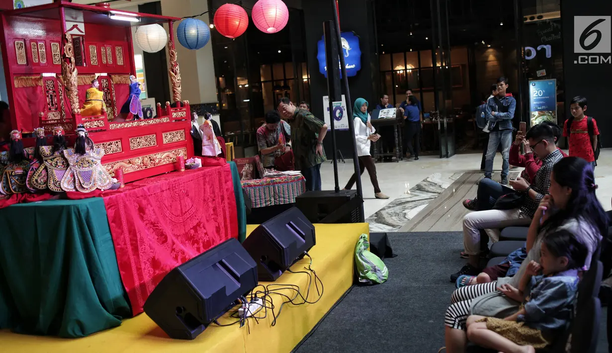 Pengunjung menyaksikan pementasan wayang potehi di salah satu mall di Jakarta, Jumat (1/2). Pementasan wayang potehi  tersebut diadakan dalam rangka menyambut Tahun Baru Imlek. (Liputan6.com/Faizal Fanani)