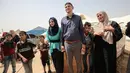 Pasangan petugas medis Muadh Al-Raqab (tengah) dan Hadeel Al-Najjar yang baru menikah berfoto di luar tenda di jalur Gaza selatan, Palestina (2/5). (AFP Photo/Said Khatib)