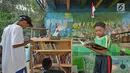 Anak-anak membaca buku di Saung Pustaka Air di Depok, Jawa Barat, (30/5). Perpustakaan ini menjadi sarana edukasi untuk menjaga dan mengenalkan area konservasi keanekaragaman hayati. (Liputan6.com/Herman Zakharia)