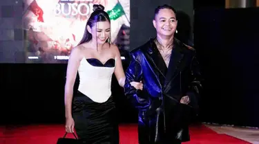 Menggandeng seorang wanita usai rumah tangganya dengan Wendy Walters retak, memunculkan dugaan kalau Shakilla Astari merupakan pacar baru Reza Arap. Dalam momen tersebut, Shakilla tampil cantik dengan corset dress black and white yang terbuat dari bahan satin. Sementara, Reza tetap stylish dengan outfit serba hitam (Liputan6.com/IG/@ybrap)