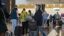 Orang-orang berbaris untuk dites Covid-19 di bandara OR Tambo di Johannesburg, Jumat (26/11/2021). Sejumlah negara menghentikan perjalanan udara dari Afrika Selatan terkait kemunculan varian baru COVID-19 yang berpotensi lebih menular yang telah terdeteksi di Afrika Selatan. (AP/Jerome Delay)