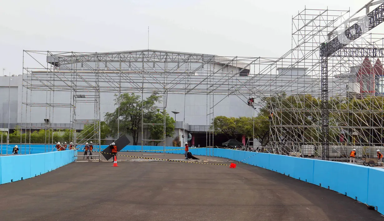 Para pekerja melakukan proses pembangunan Jakarta International E-Prix Circuit di kawasan Ancol, Jakarta, Selasa (17/5/2022). Federation Internationale de Automobile (FIA) Formula E Jakarta E-Prix menyatakan ajang balap mobil listrik pada 4 Juni mendatang diharapkan mampu memberi kontribusi positif terhadap kebangkitan ekonomi pascapandemi COVID-19 yang bakal dirasakan pelaku usaha dan masyarakat melalui Jakarta E-Prix. (Liputan6.com/Herman Zakharia)