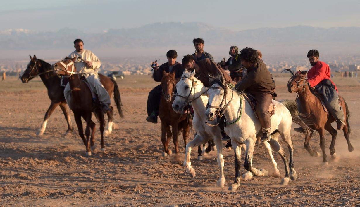 Penunggang kuda Afghanistan bersaing memperebutkan bangkai hewan dalam pertandingan Buzkashi di Herat, Afghanistan (4/2/2022). Buzkashi merupakan tradisi yang dilakukan oleh warga Afghanistan yang setiap pesertanya harus menunggang kuda. (AFP/Wakil Kohsar)