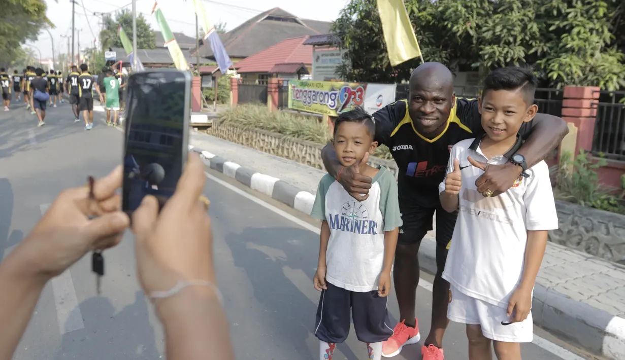 Pemain Mitra Kukar, O.K John foto bersama anak-anak seusai latihan jelang semi final Piala Presiden melawan Persib di Tenggarong, Kaltim, Minggu (4/10/2015). (Bola.com/Vitalis Yogi Trisna)