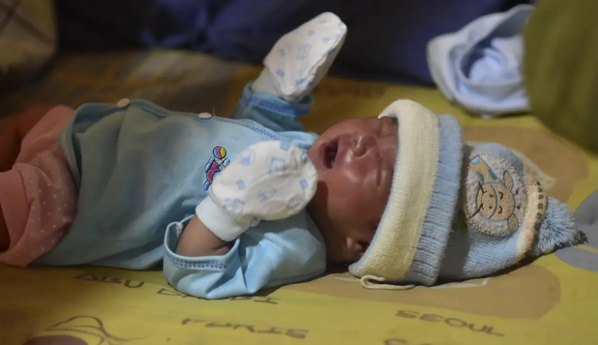 Bayi laki-laki berusia sehari, Muhammad Al Aksa, beristirahat di tempat pengungsian sementara di kota Mamuju, Sulawesi, Selasa (19/1/2021).  Basarnas menyebut hingga pukul 16.00 WIB, Senin (18/1/2021) sebanyak 84 orang meninggal akibat gempa yang terjadi di Sulawesi Barat (Sulbar). (AFP/Firdaus)