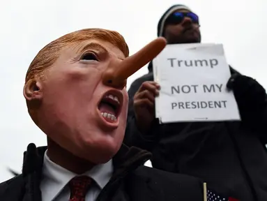 Demonstran menggelar aksi protes jelang pelantikan Donald Trump sebagai Presiden AS di Washington DC, Jumat (20/1). Mereka menolak Trump sebagai Presiden AS. (AFP PHOTO / Jewel SAMAD)