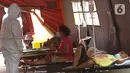 Petugas medis berbincang dengan pasien COVID-19 di ruang IGD (Instalasi Gawat Darurat) di RSUD Bekasi, Rabu (23/6/2021). Pemkot Bekasi mendirikan tenda untuk ruang IGD yang dapat menampung 30 pasien karena keterisian tempat tidur penuh akibat lonjakan kasus COVID-19. (Liputan6.com/Herman Zakharia)