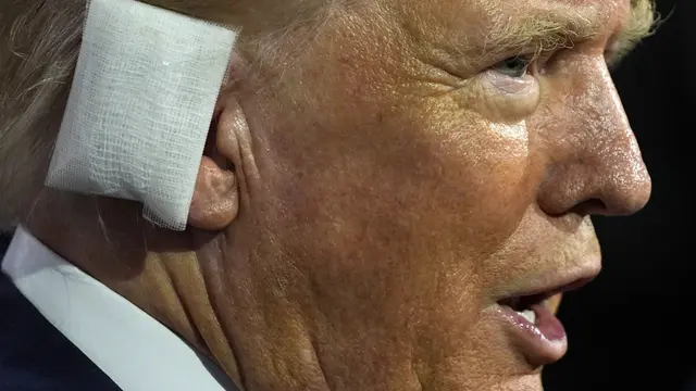 Donald Trump dengan perban di telinga, mengangkat tinjunya ke udara ketika massa bersorak atas kedatangannya di RNC atau Konvensi Partai Demokrat. (AP).