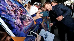 Chris Hemsworth yang memerankan sosok Thor berswafoto dengan penggemar setibanya pada world premiere film Avengers: Endgame di Los Angeles, California, Selasa (23/4). Avengers: Endgame akan tayang mulai 26 April di Amerika dan 24 April besok di Indonesia. (REUTERS/Mario Anzuoni)